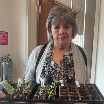 Patient holding a tray of seedling she grew during occupational therapy