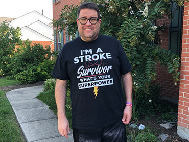 Antone Baioni stands outside his home.