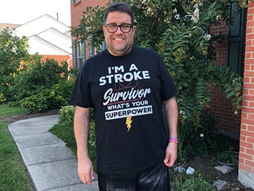 Antone Baioni stands outside his home.