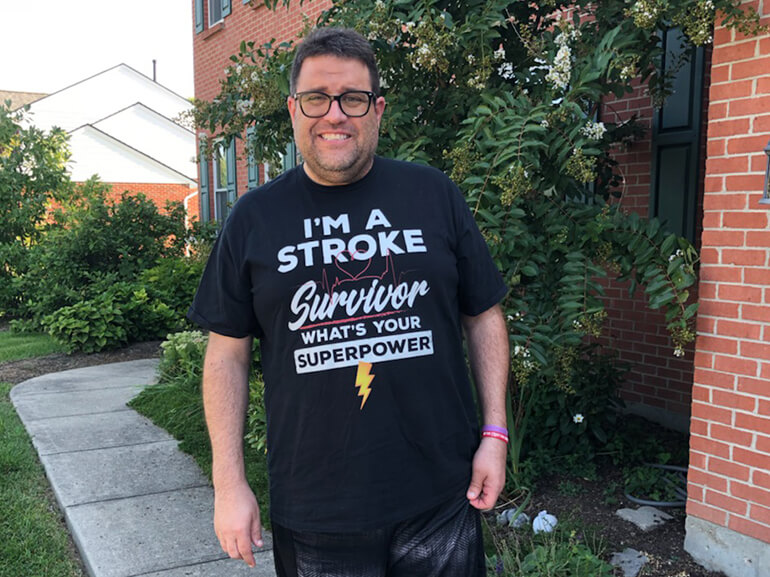 Antone Baioni stands outside his home.