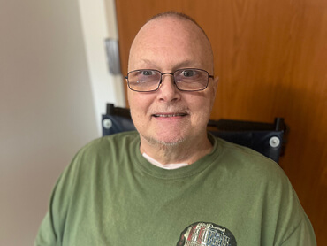 Chris Music smiles in his inpatient hospital room.