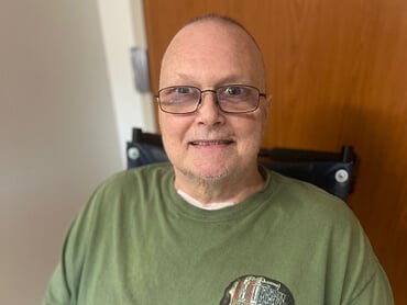 Chris Music smiles in his inpatient hospital room.