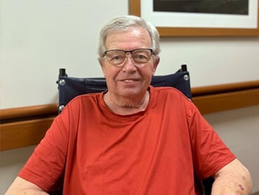 Kerry Crone smiling in his wheelchair.