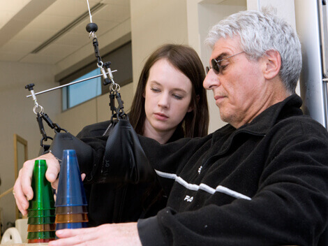 Male patient stacking small plastic cups as part of his therapy.