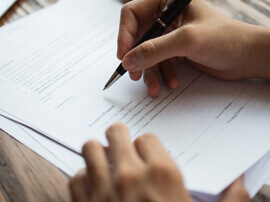 Close up of hand signing a paper.