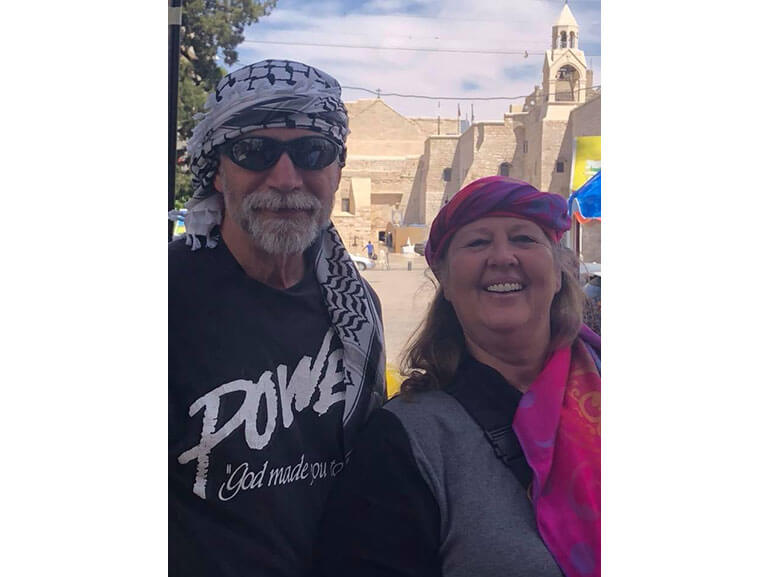 Bill wearing sunglasses and standing next to a woman outside of a church.