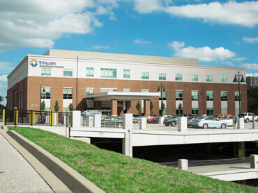 Exterior view of TriHealth Hospital on sunny day.