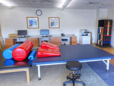 Red therapy bolsters on top of blue upholstered therapy table.